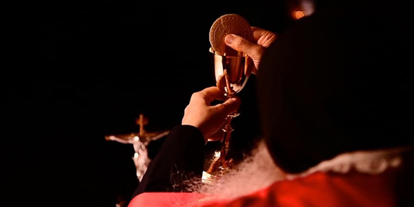 Um padre elevando a Hóstia Consagrada