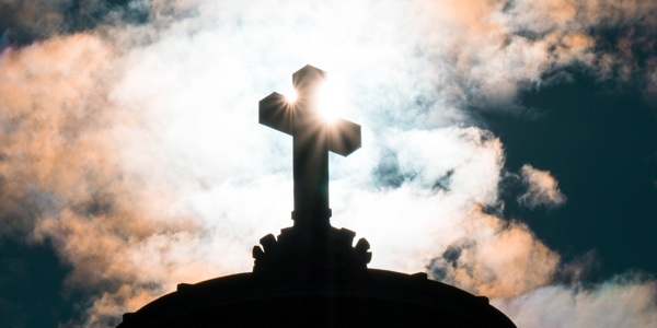 Uma cruz no alto de uma montanha coberta de neve